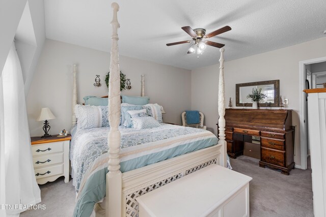 carpeted bedroom with ceiling fan and a textured ceiling