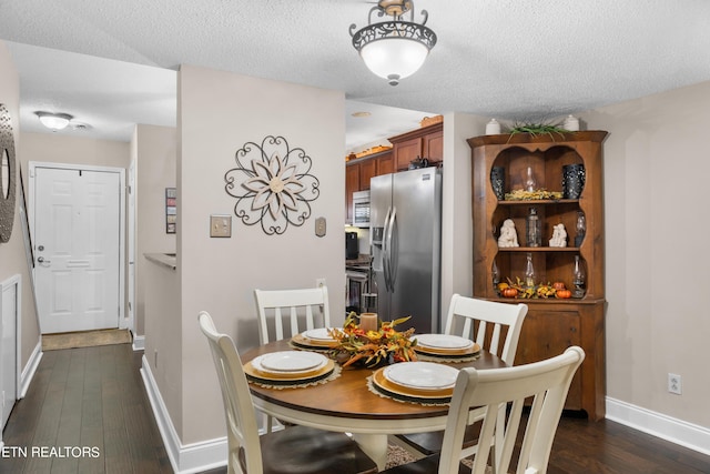 dining space with a textured ceiling and dark hardwood / wood-style floors