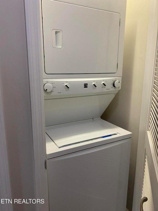 clothes washing area featuring stacked washer and dryer