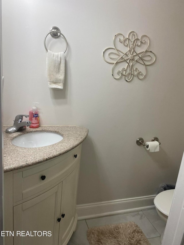 bathroom with tile patterned flooring, vanity, and toilet