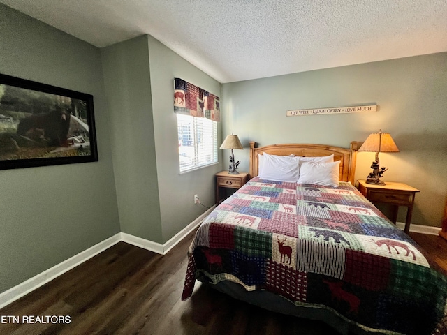 bedroom featuring a textured ceiling and dark hardwood / wood-style floors