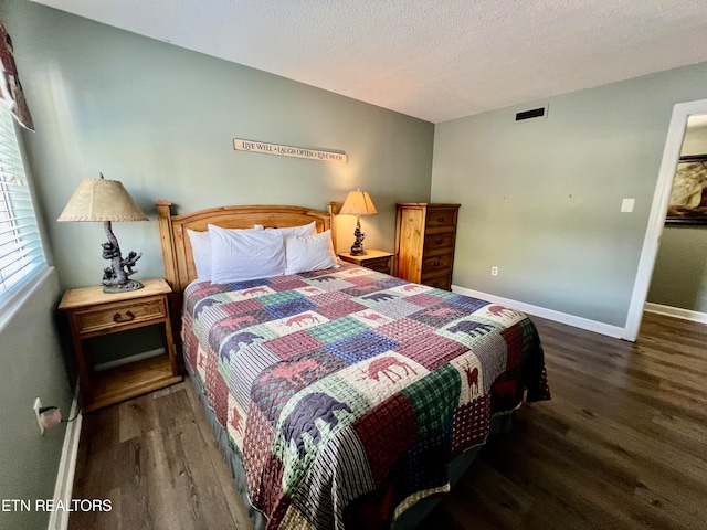 bedroom featuring a textured ceiling and dark hardwood / wood-style floors