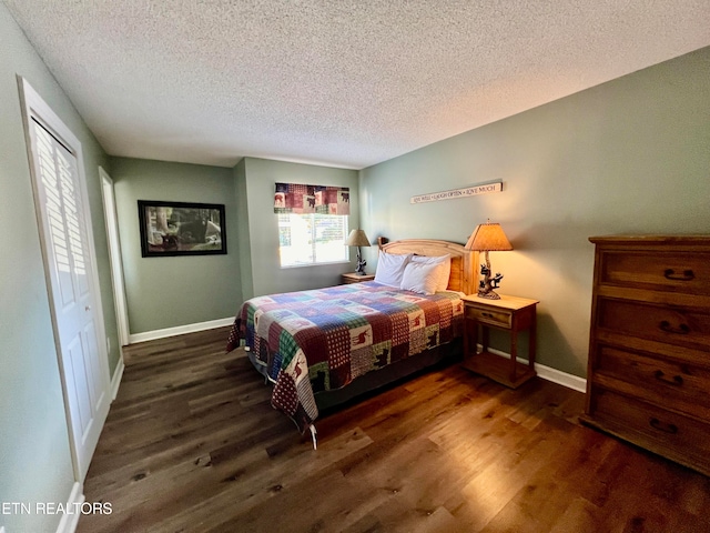 bedroom with a textured ceiling and dark hardwood / wood-style floors