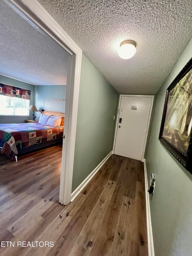 doorway featuring a textured ceiling and hardwood / wood-style floors