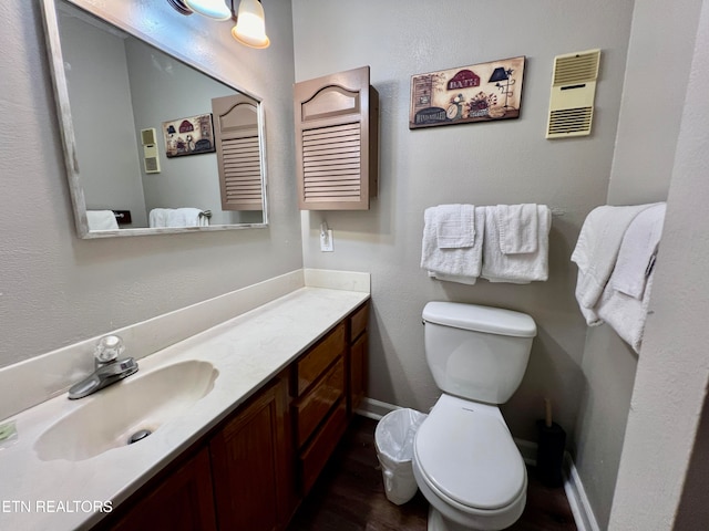 bathroom featuring wood-type flooring, vanity, and toilet