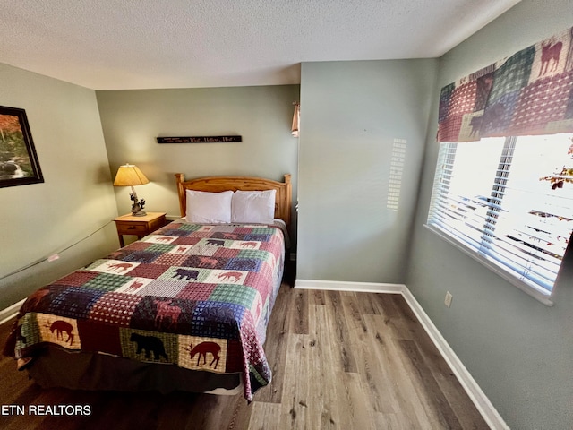 bedroom featuring a textured ceiling and hardwood / wood-style flooring