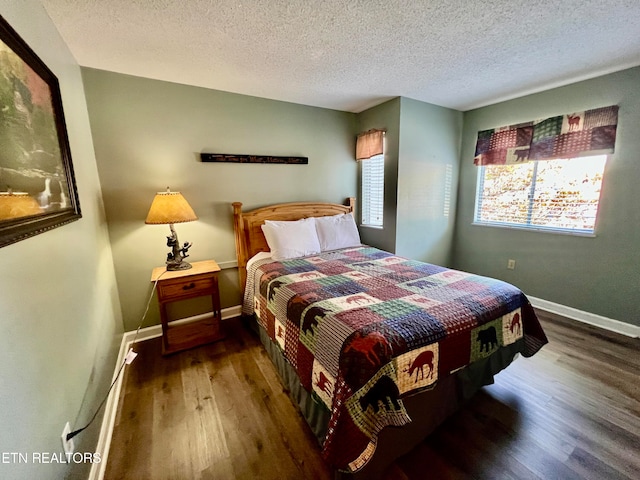 bedroom featuring a textured ceiling and dark hardwood / wood-style floors