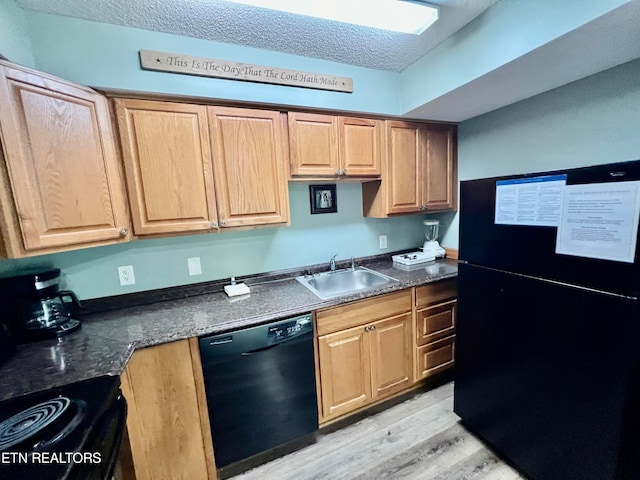 kitchen with sink, a textured ceiling, light hardwood / wood-style flooring, black appliances, and dark stone counters