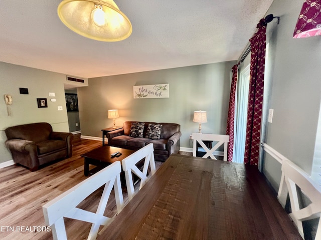 dining space featuring a textured ceiling and hardwood / wood-style floors