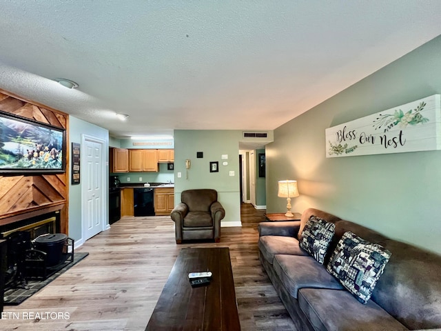 living room with light wood-type flooring and a textured ceiling