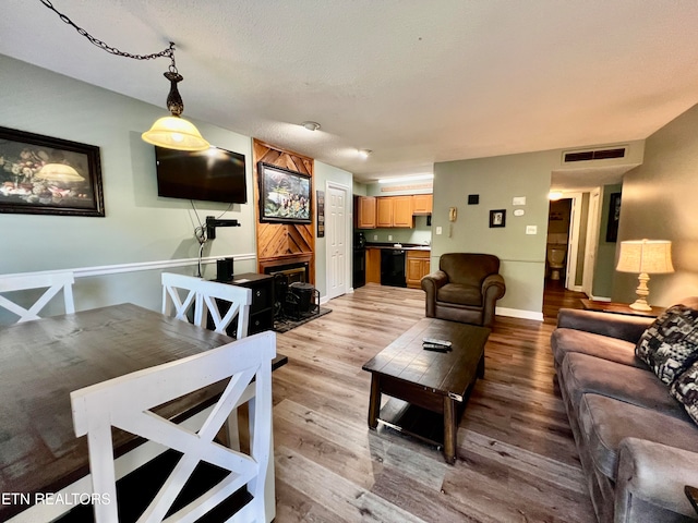 living room with light hardwood / wood-style floors and a textured ceiling