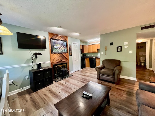 living room with light hardwood / wood-style floors and a textured ceiling