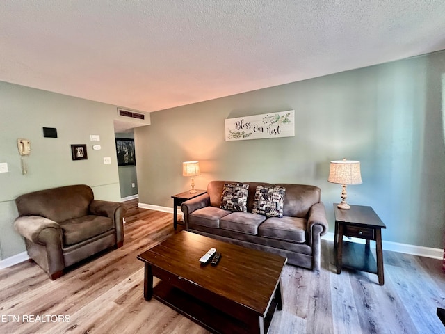 living room featuring a textured ceiling and light hardwood / wood-style floors