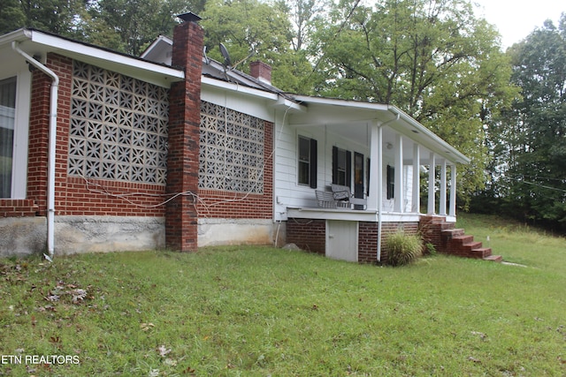 view of home's exterior with a lawn and a porch