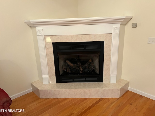 interior details featuring hardwood / wood-style floors and a tiled fireplace