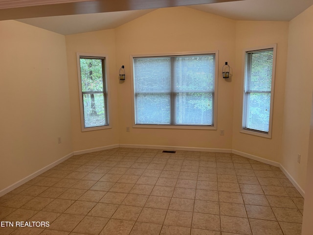 tiled empty room with vaulted ceiling