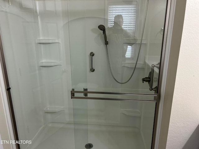 bathroom featuring a shower with shower door