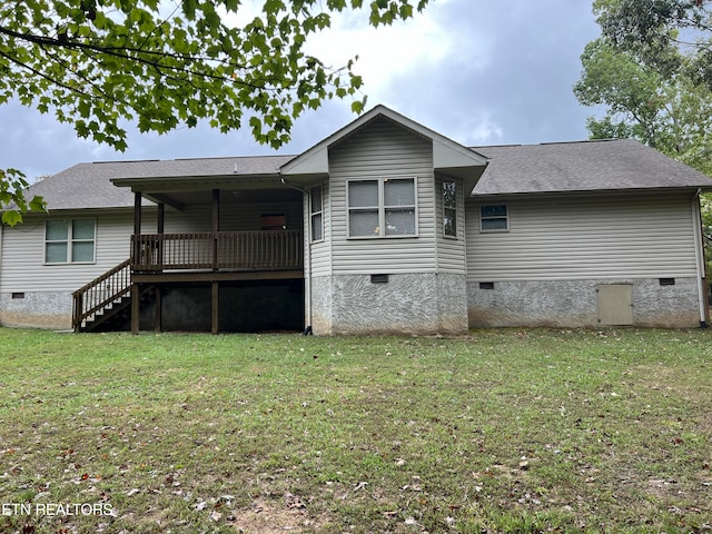 back of property with a deck and a yard