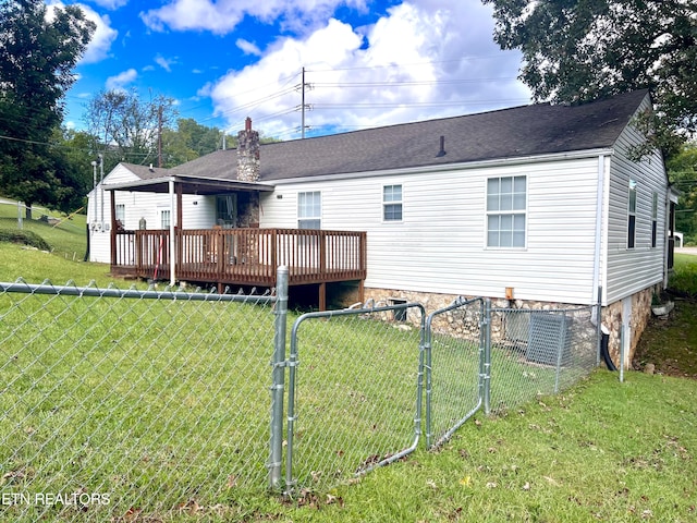 rear view of house featuring a deck and a yard