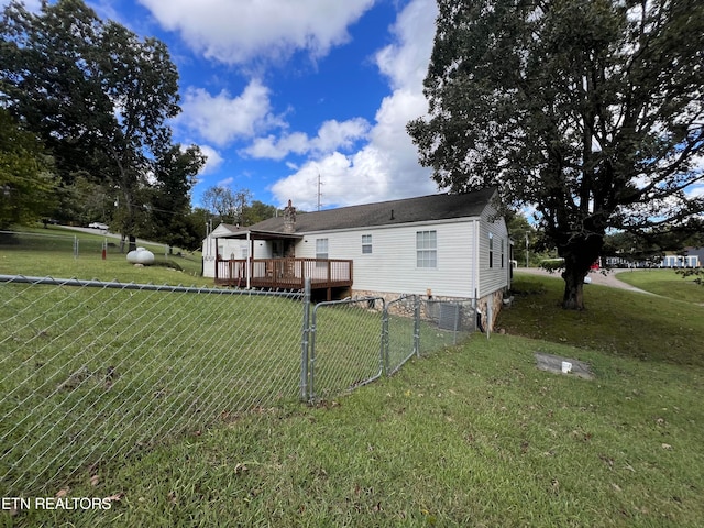 rear view of property featuring central AC unit, a wooden deck, and a yard