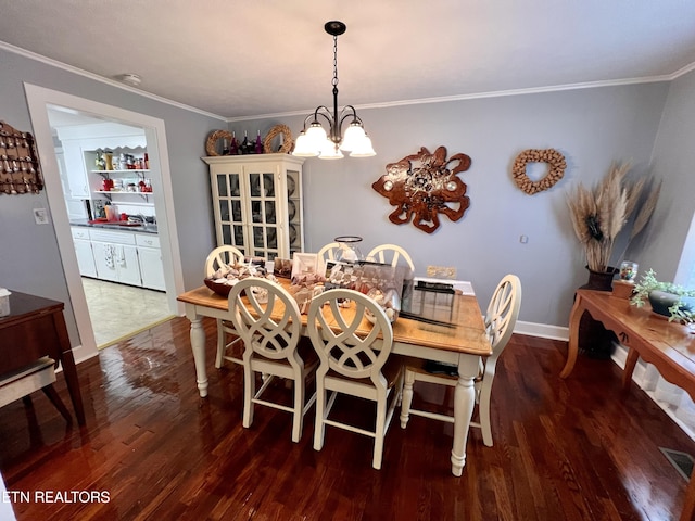 dining space featuring crown molding, dark hardwood / wood-style floors, and a notable chandelier