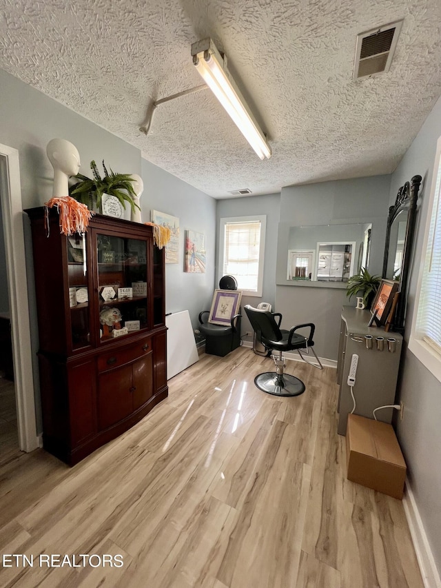 sitting room with light hardwood / wood-style floors and a textured ceiling