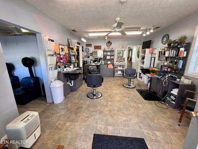 interior space with a textured ceiling and ceiling fan