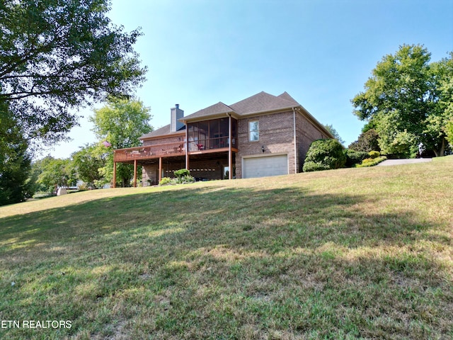 view of front of property with a garage, a deck, a front lawn, and a sunroom