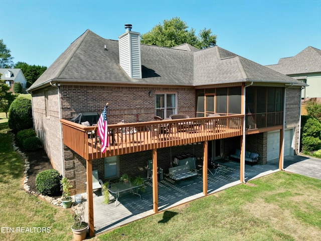 rear view of house featuring a wooden deck, a patio, a sunroom, and a lawn