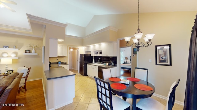 dining space with light tile patterned flooring, sink, an inviting chandelier, high vaulted ceiling, and crown molding