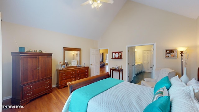 bedroom with ceiling fan, ensuite bathroom, light hardwood / wood-style floors, and high vaulted ceiling