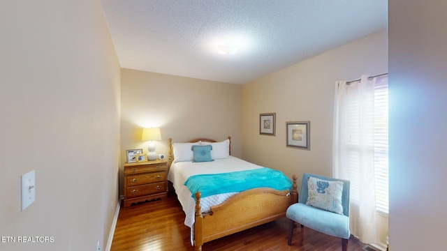 bedroom featuring a textured ceiling and wood-type flooring