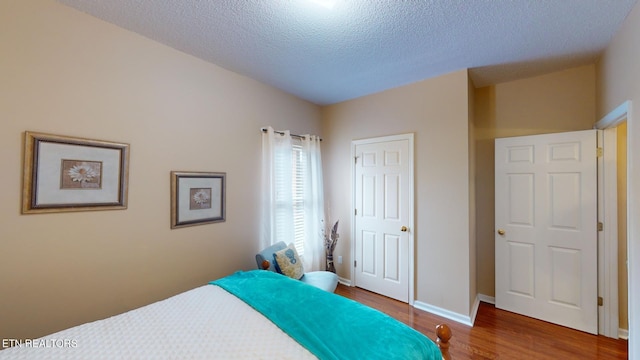 bedroom featuring a textured ceiling and hardwood / wood-style floors