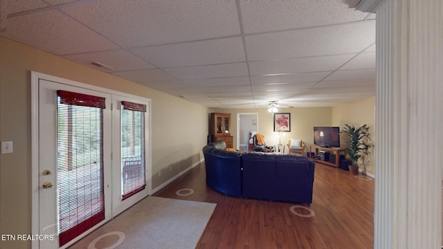 living room featuring ceiling fan, dark hardwood / wood-style floors, and a paneled ceiling