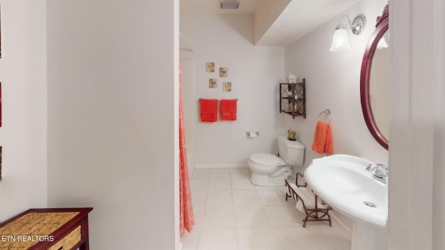 bathroom featuring tile patterned flooring, toilet, and sink