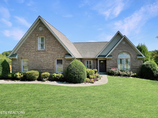 traditional-style home featuring a front lawn and brick siding