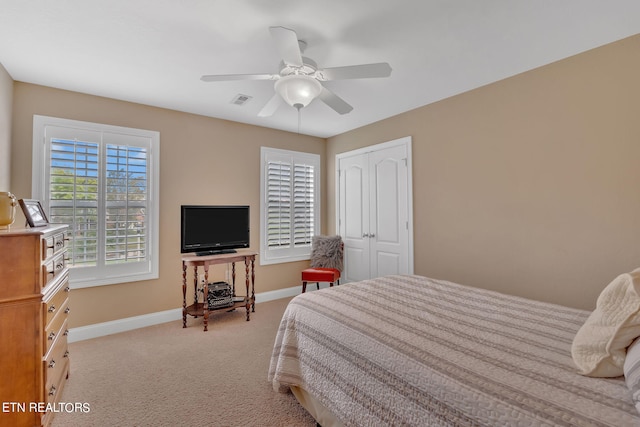 carpeted bedroom with ceiling fan and a closet