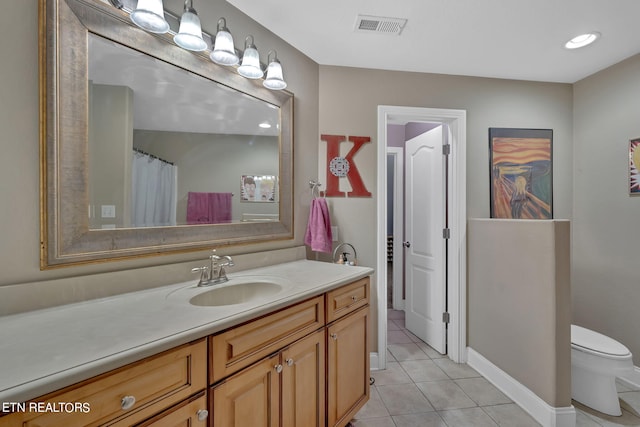 bathroom featuring vanity, toilet, and tile patterned floors