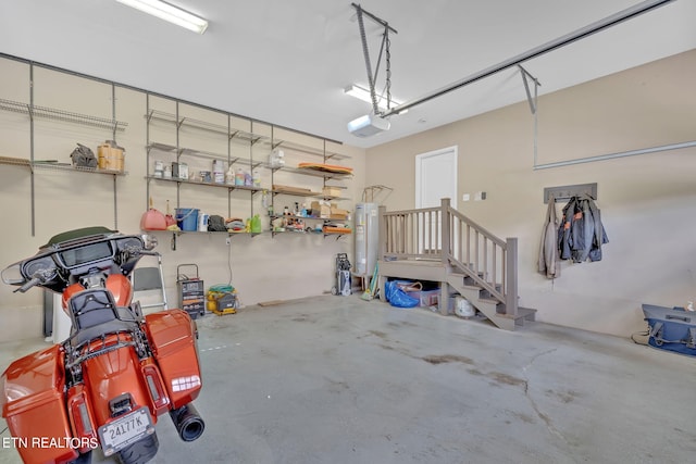 garage with electric water heater and a garage door opener