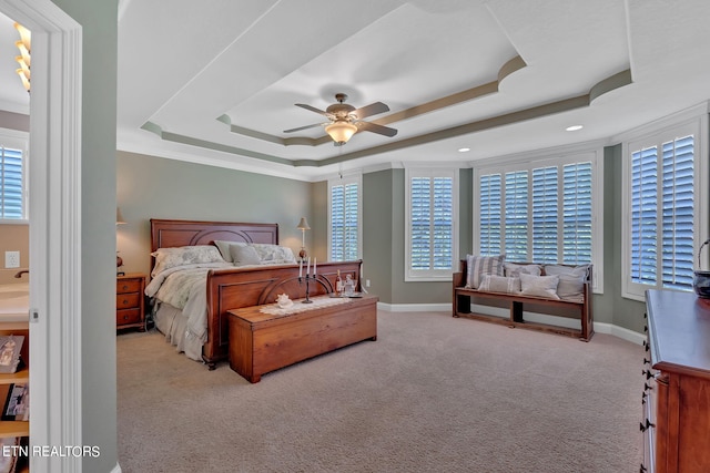 carpeted bedroom featuring ceiling fan and a raised ceiling