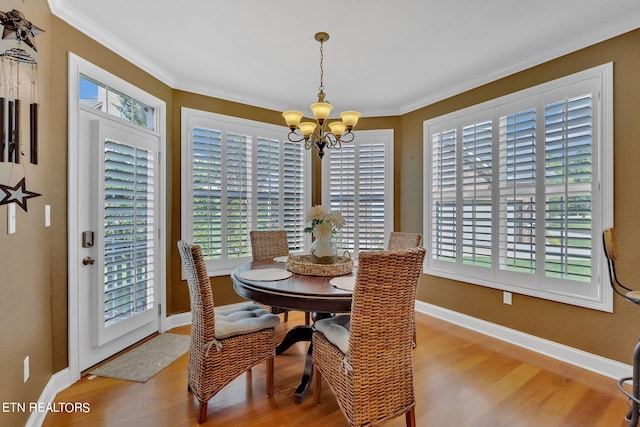 dining room featuring crown molding, light hardwood / wood-style floors, and a chandelier