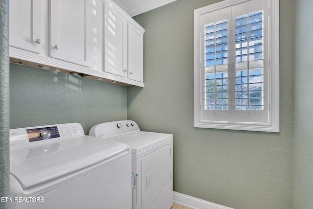 clothes washing area with ornamental molding, washing machine and clothes dryer, and cabinets