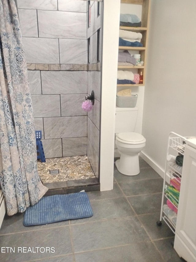 bathroom featuring toilet, tile patterned floors, and a shower with curtain