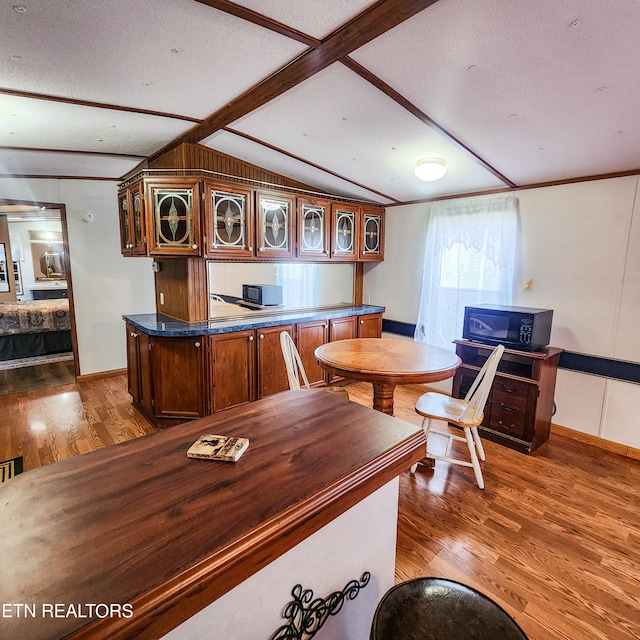 office with a textured ceiling, vaulted ceiling with beams, and dark hardwood / wood-style flooring