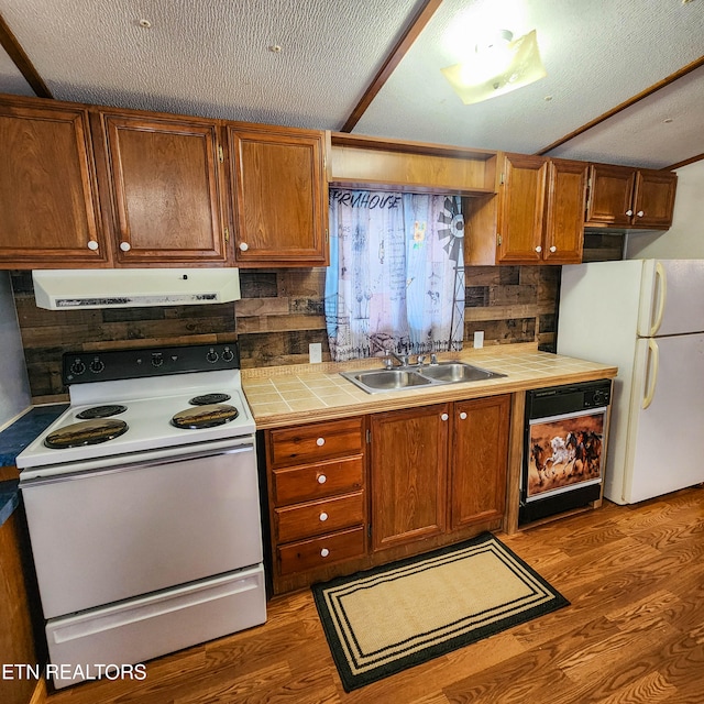 kitchen featuring a textured ceiling, white appliances, sink, and range hood