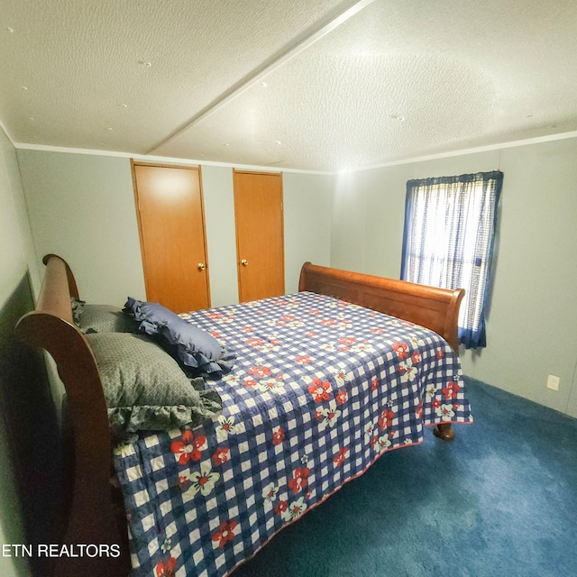 bedroom with a textured ceiling, carpet, and ornamental molding