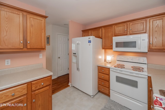 kitchen featuring light hardwood / wood-style flooring and white appliances