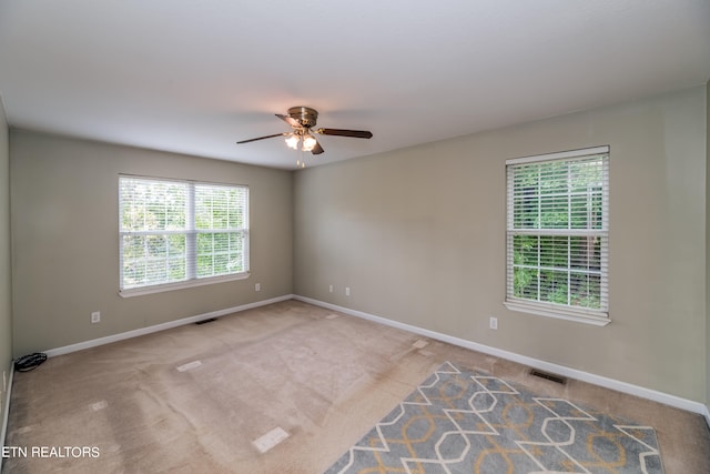 empty room featuring ceiling fan and light colored carpet