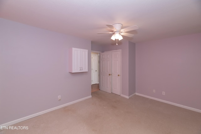 carpeted empty room featuring ceiling fan