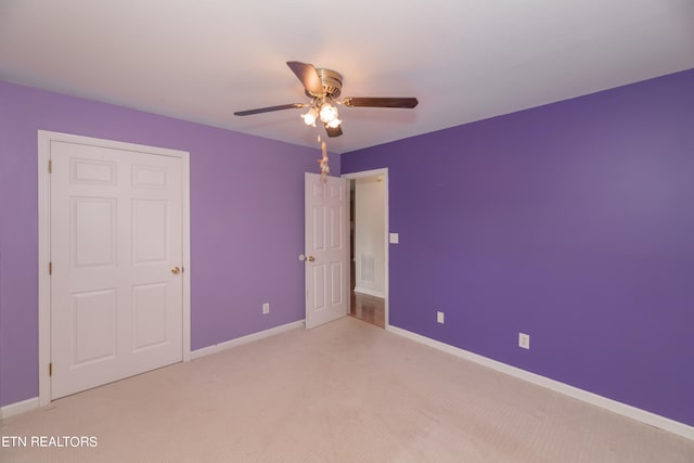 unfurnished bedroom with ceiling fan and light carpet